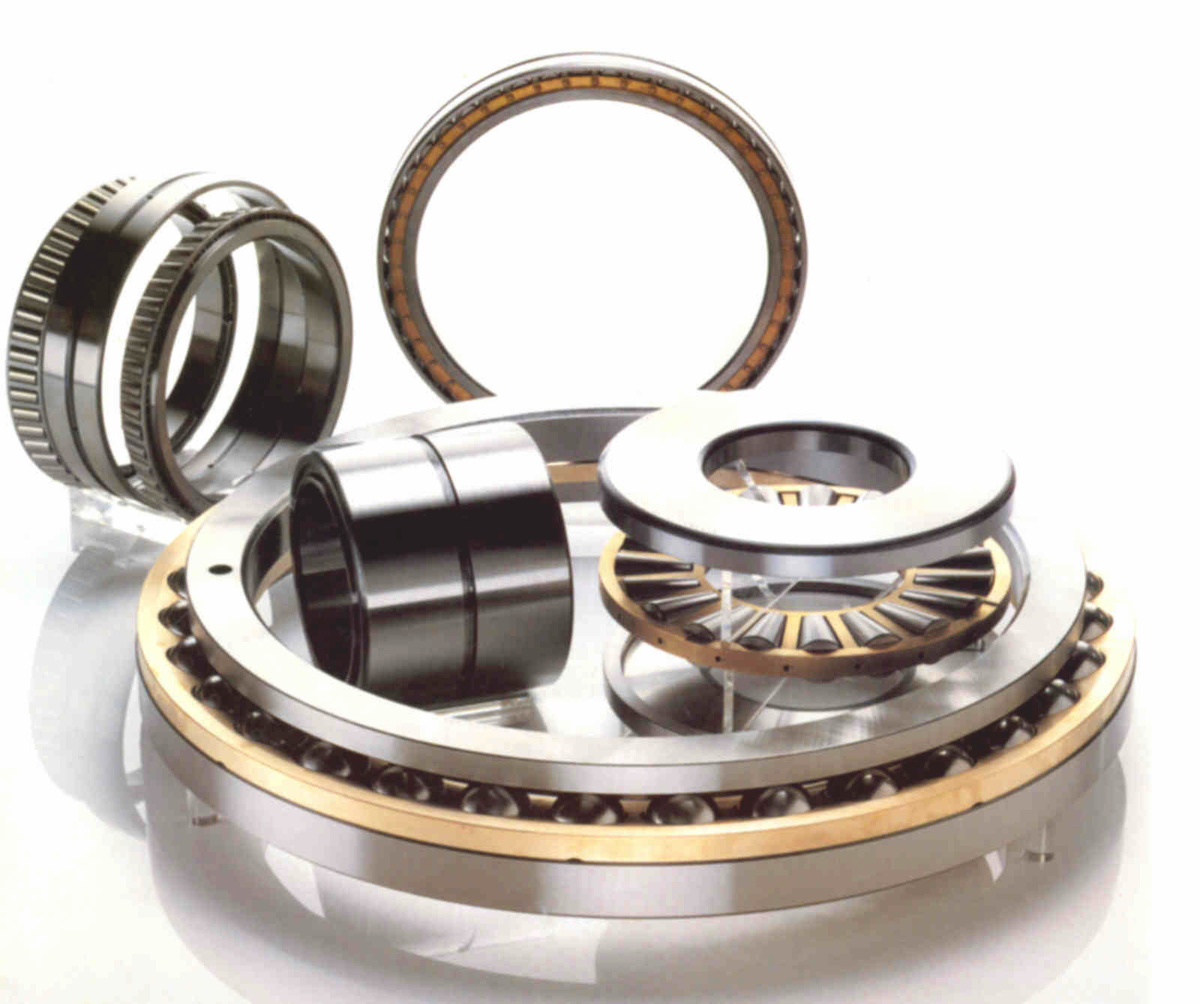 A set of industrial ball bearings and bearing components arranged on a clean white studio background, including a large outer bearing, inner rings, and metal rings with visible bronze-toned inner races.